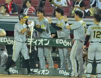 　９回、代打・原口の適時打で生還しナインの出迎えに笑顔を見せる熊谷（左端）＝撮影・立川洋一郎