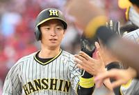 　２回、中野の適時打で生還し、ナインとタッチを交わす近本