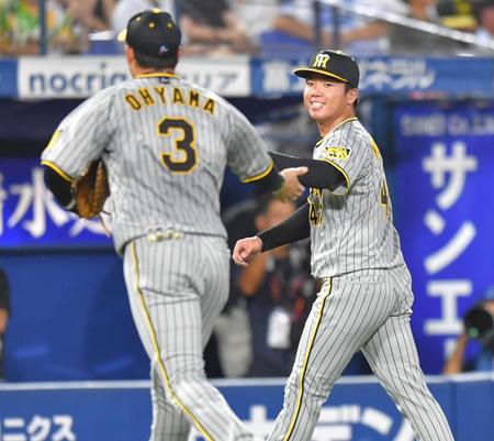 ３回を無失点に抑え、大山（左）とタッチする村上（撮影・西岡正）