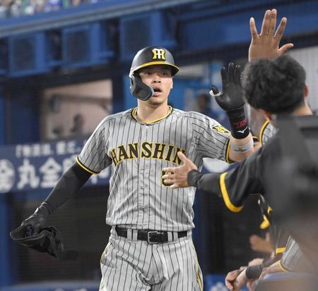 　９回、右前打を放ち代走を送られ、ベンチ前でナインとタッチを交わす佐藤輝