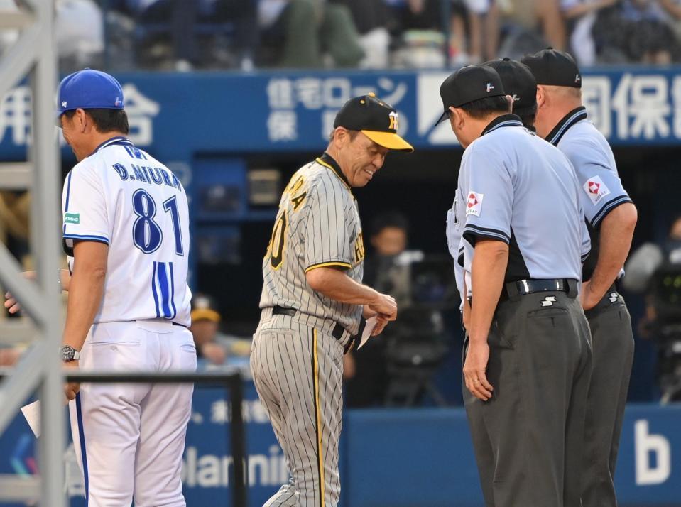 　審判とは握手せず、苦笑いでベンチへ戻る岡田監督（撮影・西岡正）