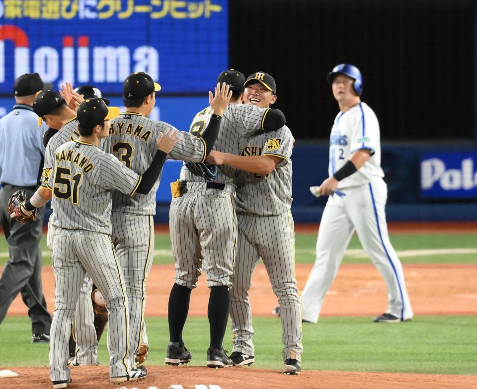 　９回、完封で今シーズン８勝目を挙げて佐藤輝と抱き合う伊藤将。後方は牧（撮影・堀内翔）