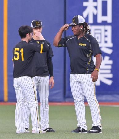 　敬礼ポーズであいさつを交わすミエセス（右）と中野（左）＝撮影・立川洋一郎