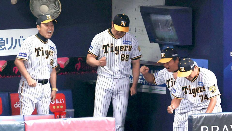 　１０回、満塁のピンチをしのいでガッツポーズする岡田監督（左）ら阪神ベンチ（撮影・山口登）