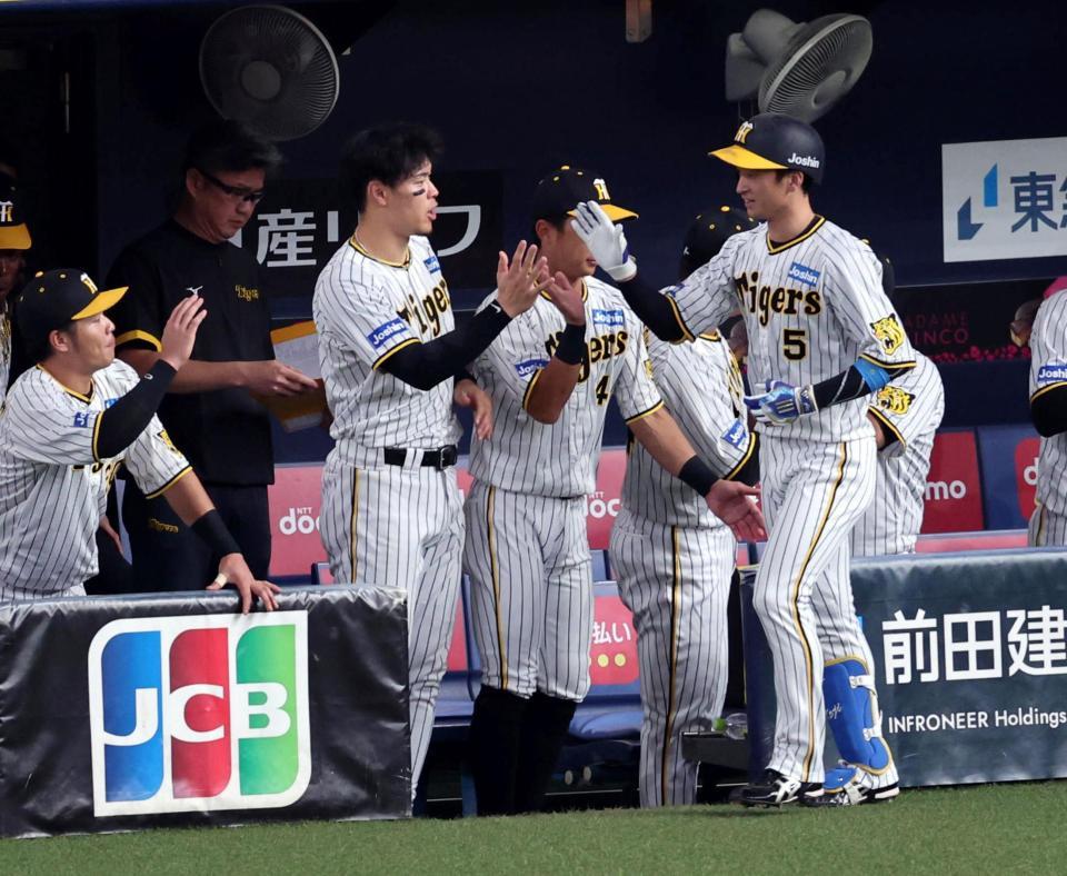 　６回、ソロを放った近本を迎える佐藤輝ら阪神ナイン（撮影・山口登）
