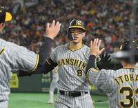 　２回、右翼スタンドへ先制ソロを放ち出迎えるナインとタッチを交わす佐藤輝（撮影・立川洋一郎）