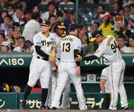 　ＫＯされた岩崎（１３）を迎える佐藤輝（左）ら阪神ナイン（撮影・中田匡峻）