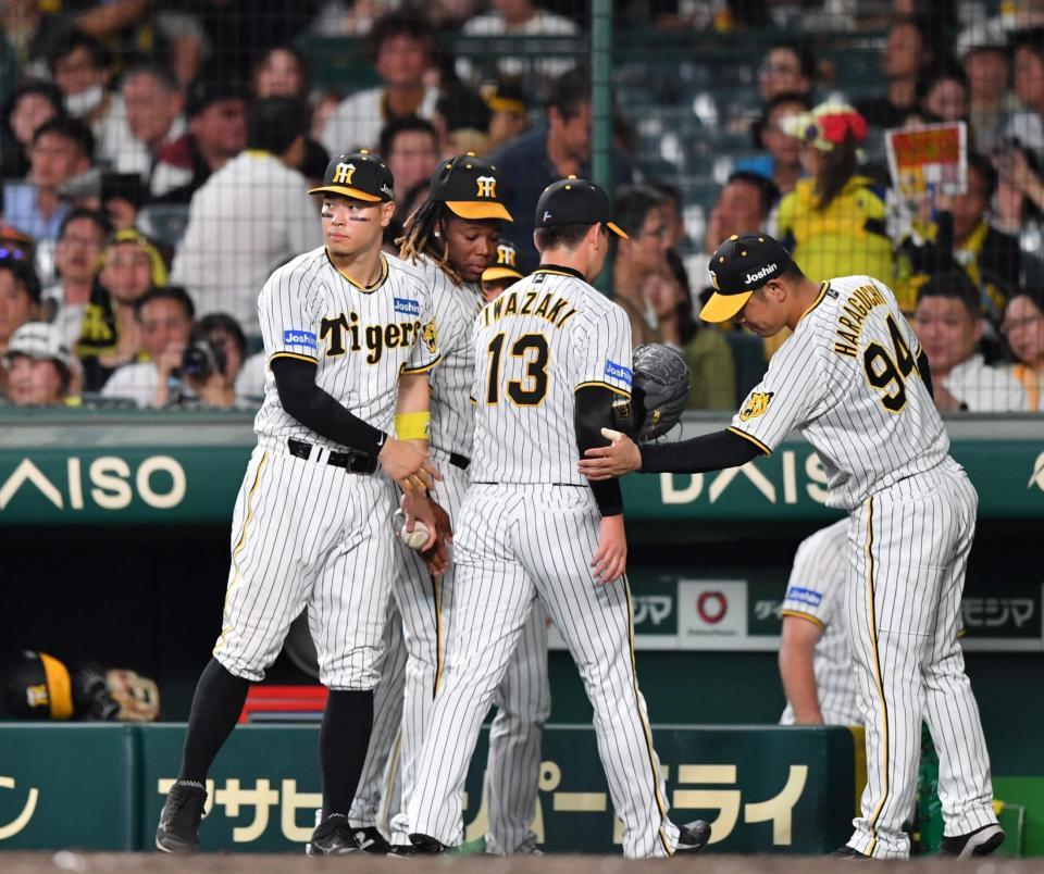 　ＫＯされた岩崎（１３）を迎える佐藤輝（左）ら阪神ナイン（撮影・中田匡峻）