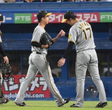 　６回、好リリーフを見せてベンチ前で青柳（右）に迎えられる島本（撮影・堀内翔）