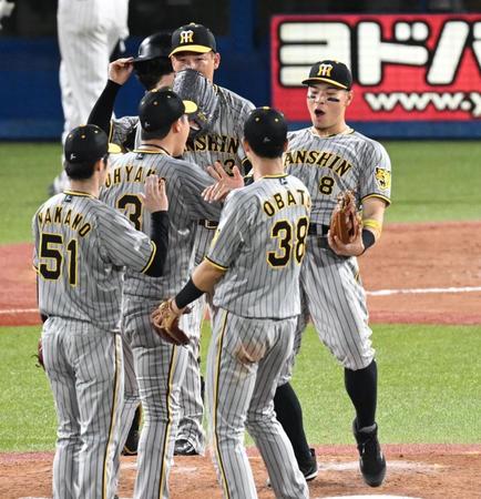 ヤクルトに連勝し喜ぶ佐藤輝らナイン（右）＝撮影・金田祐二