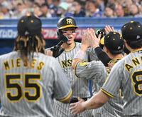 　３回、３ランを放ち、ナインとタッチを交わす佐藤輝（中央）＝撮影・高部洋祐