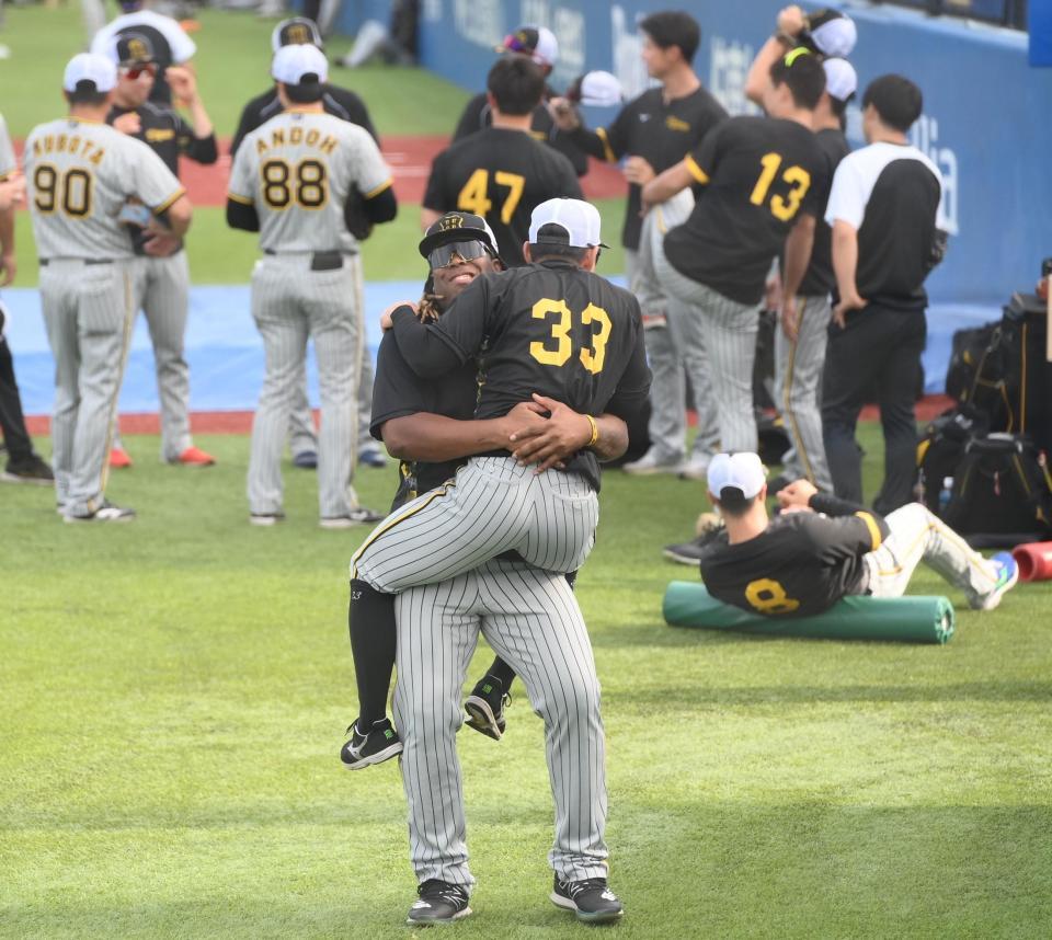 　試合前の練習中に抱きついてきた糸原（３３）を抱え上げるミエセス（撮影・堀内翔）