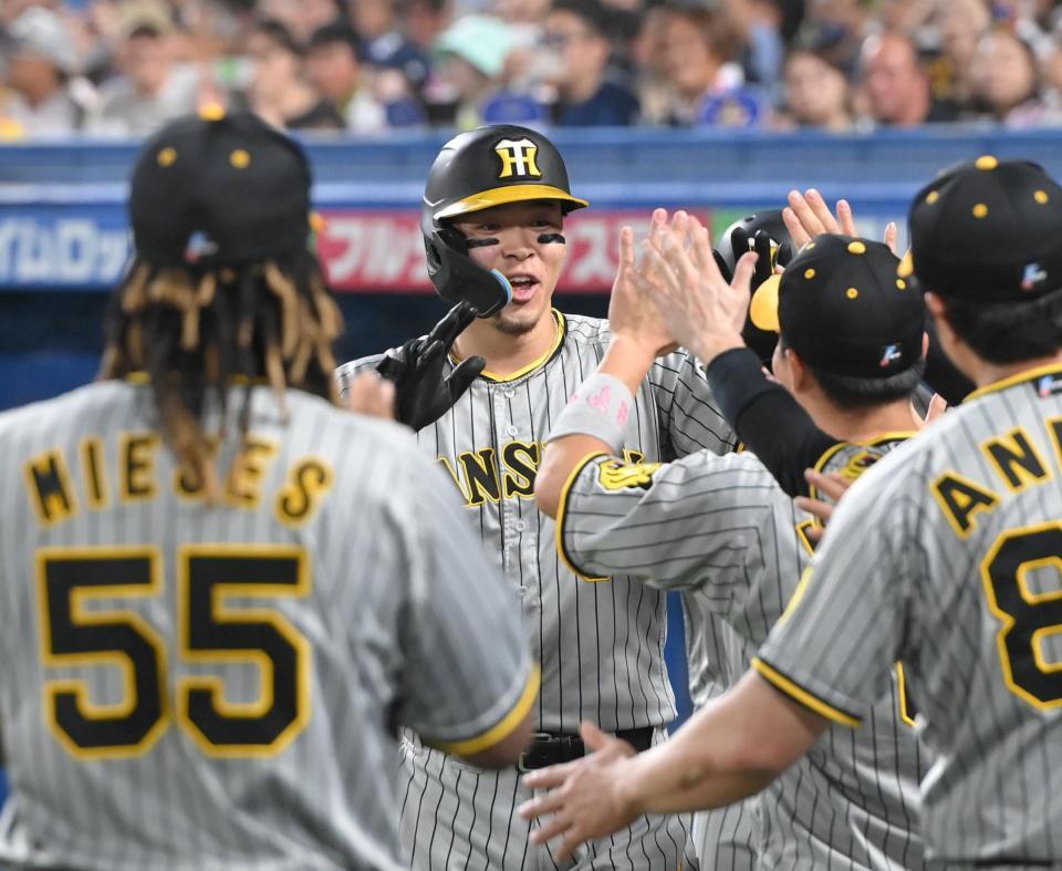 　３回、３ランを放ち、ナインとタッチを交わす佐藤輝（中央）＝撮影・高部洋祐