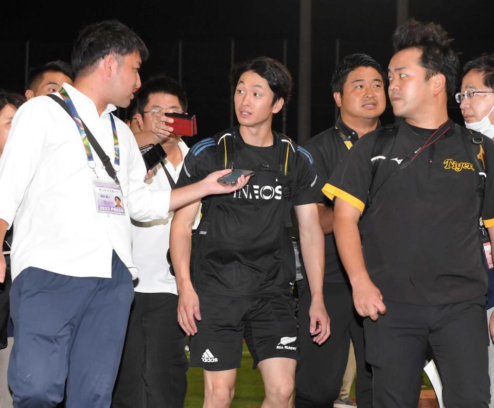 　大勢の記者に囲まれながら引き揚げる（中央）