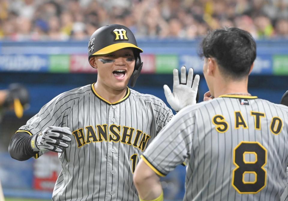 　６回、ソロを放ち佐藤輝（右）とタッチを交わす森下（撮影・金田祐二）