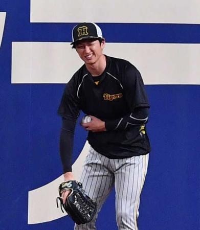 　キャッチボール中、それたボールを捕球した近本は笑いながら脇腹を押さえる