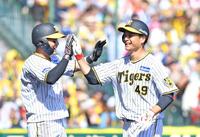　２回、近本の２点適時二塁打で生還した二走・大竹（右）は三走・木浪と笑顔でタッチを交わす（撮影・中田匡峻）