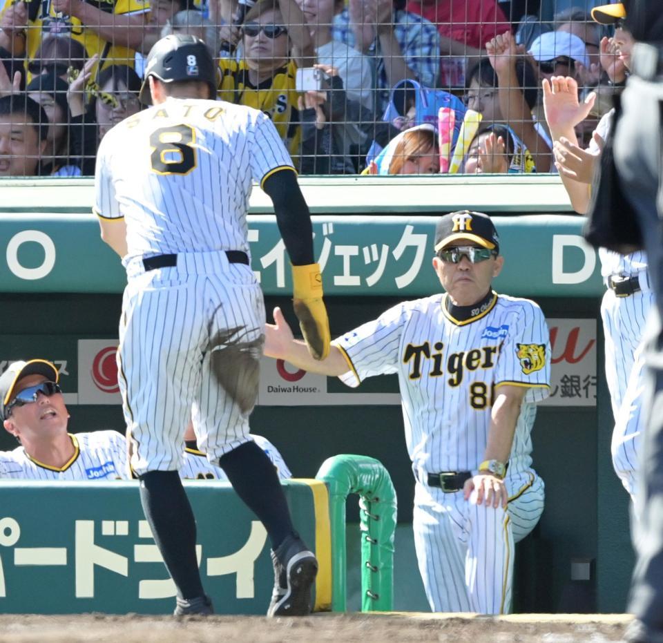 　２回、ノイジーの適時打で生還した佐藤輝（８）を迎える岡田監督（撮影・立川洋一郎）
