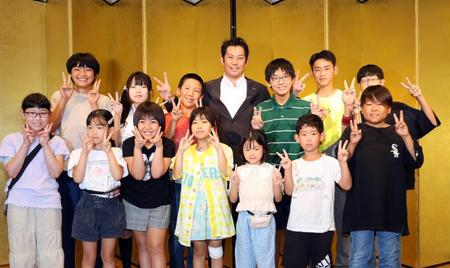 　親子観戦会を開き、子どもたちを写真に納まる岩田稔氏（中央）＝撮影・山口登