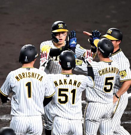 　３回、先制となる満塁本塁打を放った佐藤輝（中央左）はナインとタッチを交わす（撮影・北村雅宏）