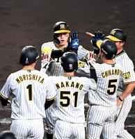 　３回、先制となる満塁本塁打を放った佐藤輝（中央左）はナインとタッチを交わす（撮影・北村雅宏）