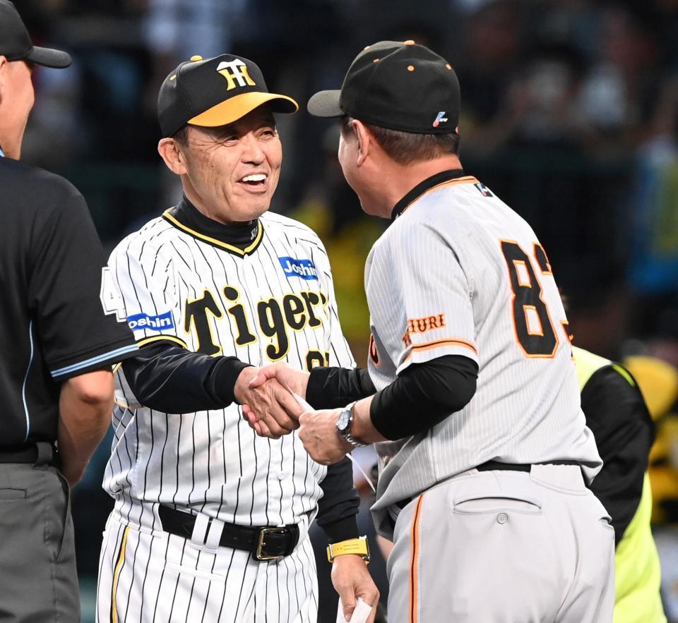 　笑顔で握手を交わす岡田監督（左）と原監督（撮影・飯室逸平）