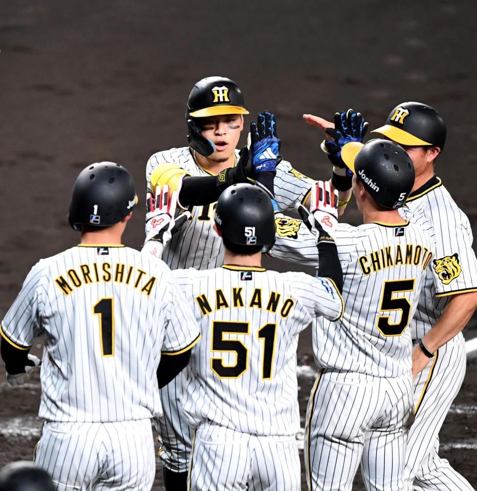 　３回、先制となる満塁本塁打を放った佐藤輝（中央左）はナインとタッチを交わす（撮影・北村雅宏）
