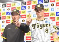 　ヒーローインタビューを終え、二人で「Ｍ１」のポーズを決める青柳（左）と佐藤輝（撮影・高部洋祐）