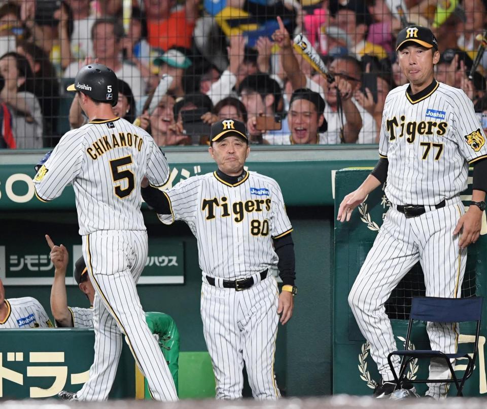 　６回塁、大山の先制中犠飛で生還した近本（左）を迎える岡田監督（撮影・中田匡峻）