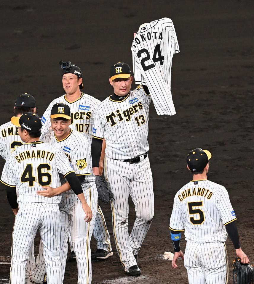 　横田慎太郎さんのユニホームを掲げる岩崎（撮影・飯室逸平）