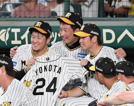 　横田慎太郎さんのユニホームを手に笑顔を見せる（左から）岩貞、岩崎、梅野＝１４日