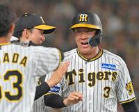 　８回、ノイジーの２点適時打で生還し、ナインの出迎えに笑顔を見せる大山（撮影・立川洋一郎）