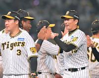 　９回表を締めくくって勝利を決め、笑顔でタッチを交わす岩崎（右端）＝撮影・立川洋一郎