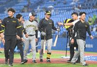 　試合前の打撃練習を終え、雨の中ベンチに下がる森下（中央）、木浪（右端）ら＝撮影・高部洋祐