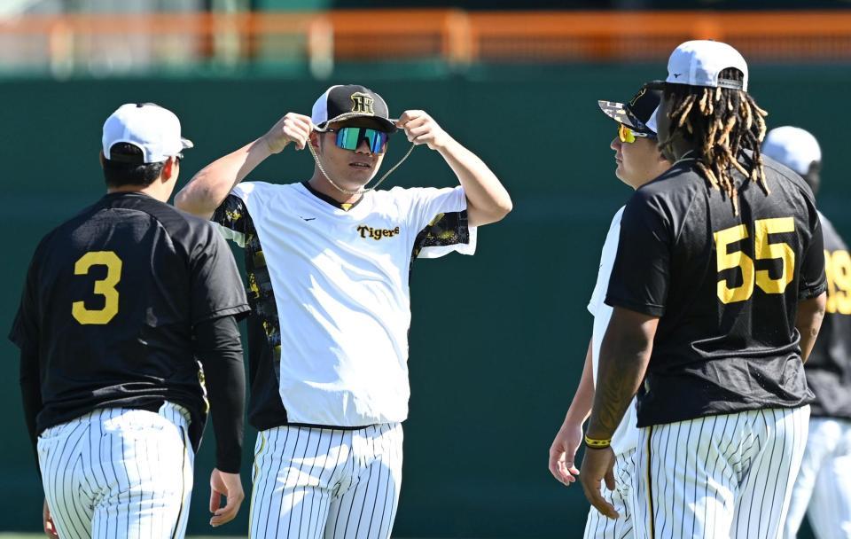 　ミエセス（５５）のネックレスを着ける小野寺（撮影・飯室逸平）