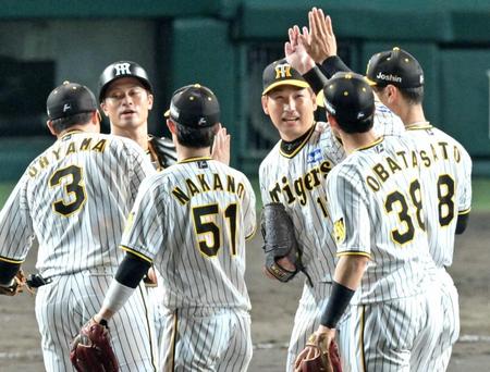 　９回表を締めくくって３４セーブ目を挙げ、ナインとタッチを交わす阪神・岩崎