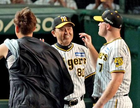 　勝利のタッチを交わして笑顔を見せる岡田監督（中央）＝撮影・立川洋一郎