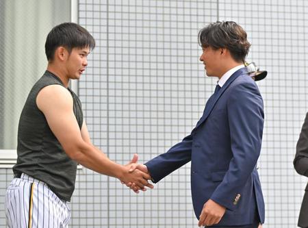 　戦力外通告を受けた北條（右）は野口と握手を交わす（撮影・中田匡峻）