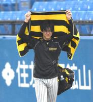 　試合前の練習中、バスタオルで雨を避けながらグラウンドを後にする及川（撮影・堀内翔）