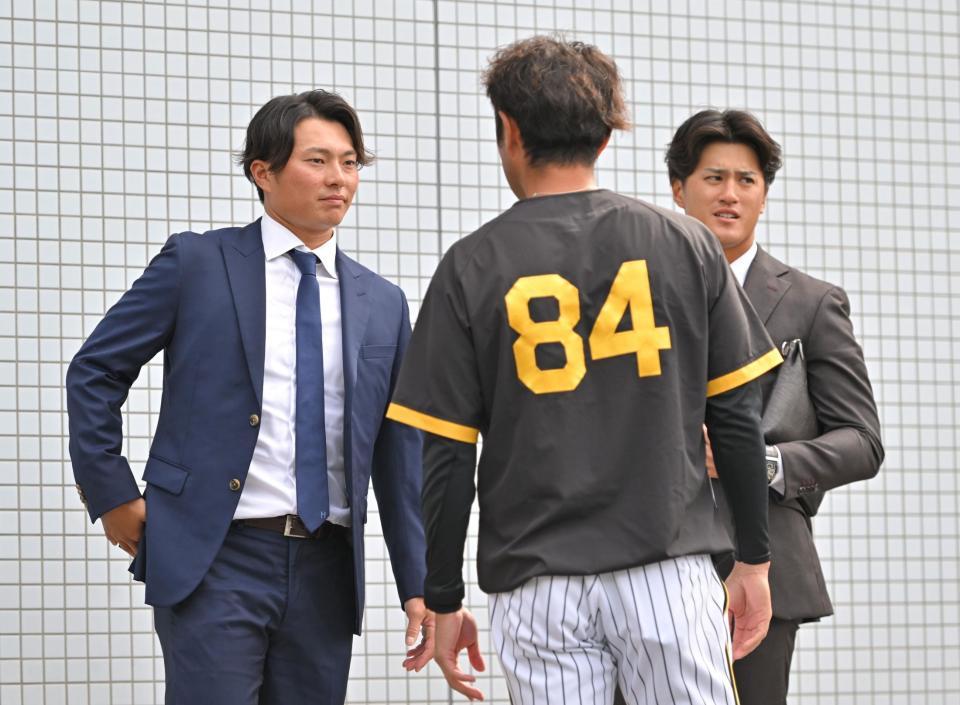 　戦力外通告を受けた北條（左）と板山（右）は日高２軍バッテリーコーチ補佐と言葉を交わす（撮影・中田匡峻）