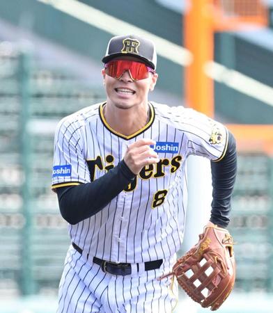 　明るい表情でノックの打球を追う佐藤輝