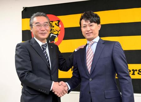 　来季のコーチ就任が決まり、嶌村聡球団本部長（左）と握手を交わす笑顔を見せる上本博紀氏（撮影・立川洋一郎）