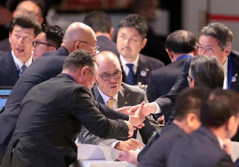 　青学大・下村海翔の交渉権獲得が決まり、握手を交わし喜ぶ岡田監督（中央）、百北球団社長（右奥）ら阪神陣営（撮影・吉澤敬太）