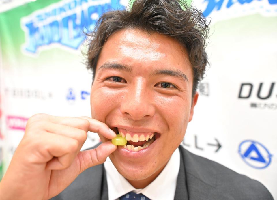 　阪神から２位指名を受けた四国ＩＬｐ徳島・椎葉剛はパインアメにかじりつく（撮影・中田匡峻）