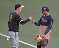 　宗（右）とグータッチする佐藤輝（撮影・西岡正）