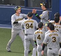 　５回、近本の２点適時三塁打で生還し、ナインとタッチを交わす渡辺諒（左端）＝撮影・高部洋祐