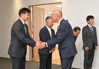 　阪神の指名あいさつを受け、畑山統括スカウト（手前右）と握手を交わすドラフト６位指名の大経大・津田淳哉（撮影・立川洋一郎）