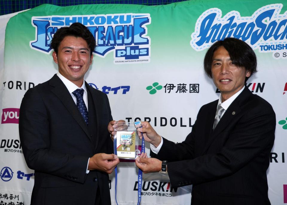 　椎葉（左）は岡田監督のサインが入ったドラフトＩＤパスを渡辺スカウトから手渡される（撮影・山口登）