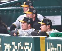 　７回途中に交代し、ベンチから試合を見る佐藤輝（右）＝撮影・西岡正