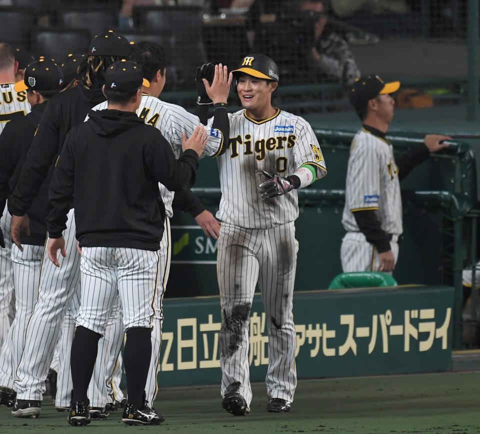 　２回、近本の適時打で勝ち越しの生還を果たした木浪（中央）はナインに迎えられる（撮影・北村雅宏）